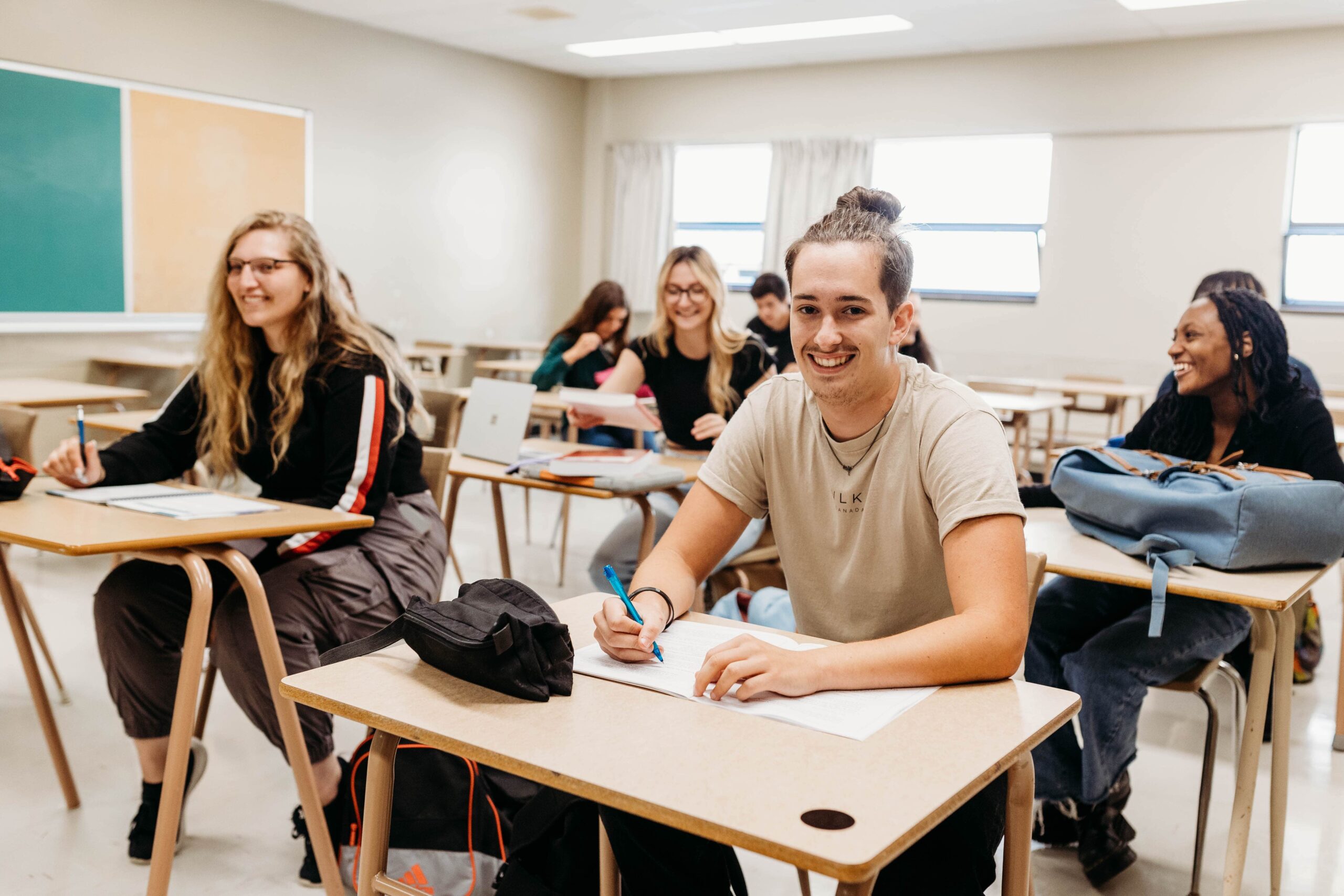 Étudiants souriant dans une classe.