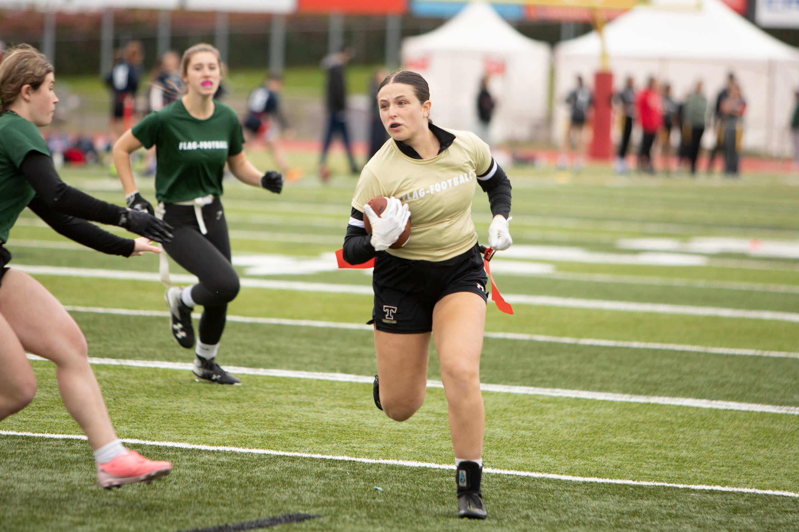 Une joueuse de flag-football court avec le ballon.